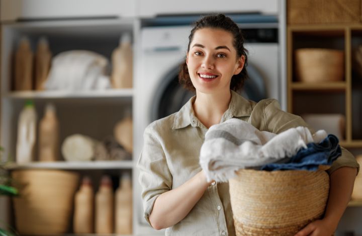 Organized small apartment laundry closet with shelves and baskets