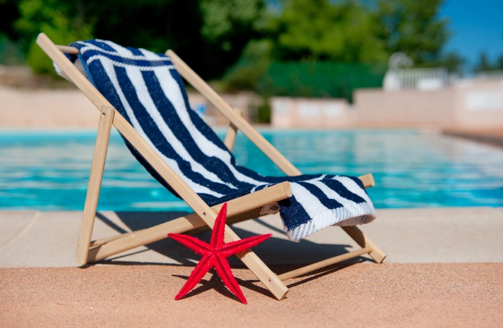 Freshly washed pool towels folded beside a swimming pool