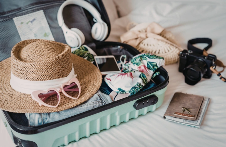 Suitcase neatly packed with summer clothes and laundry essentials for travel