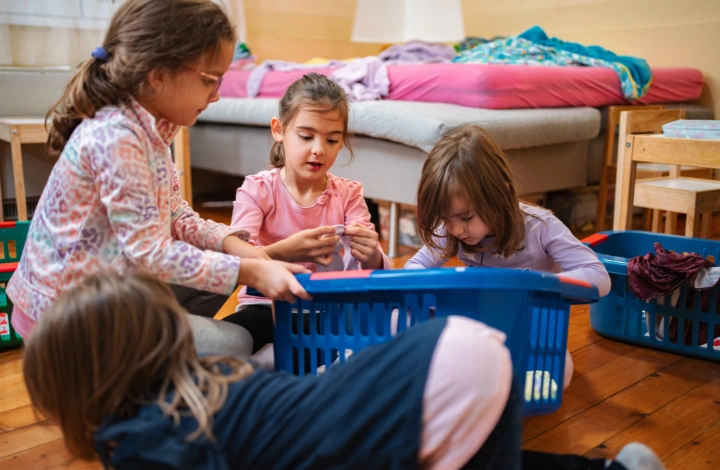 Children sorting laundry in baskets for a weekly back-to-school laundry routine